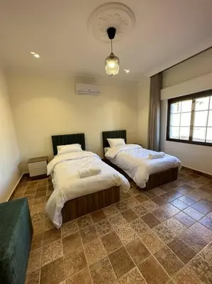a bedroom with two beds and a window at 8/ Antica jabalal-lwebdeh in Amman