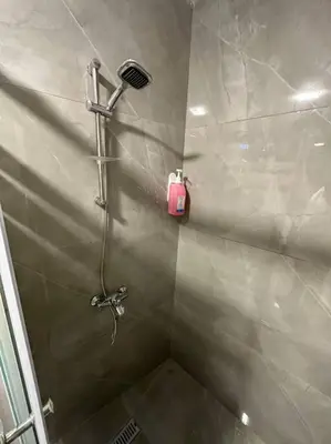 a shower stall with a pink bottle on the wall at X/ Antica jabalal-lwebdeh in Amman