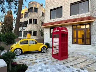 a yellow car parked next to a red phone booth at X/ Antica jabalal-lwebdeh in Amman