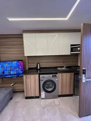a kitchen with a washing machine and a tv at X/ Antica jabalal-lwebdeh in Amman