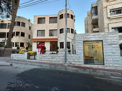 a building on the corner of a city street at XX/ Antica jabalal-lwebdeh in Amman