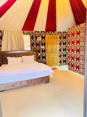 a bedroom with a bed in a circus tent at Wadi Rum Legacy Camp & Tours in Wadi Rum