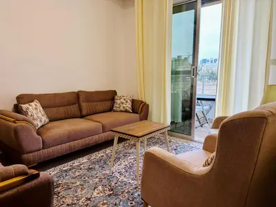 a living room with a couch and chairs and a table at Luxury Abdoun apartment in Amman