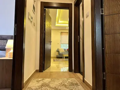 a hallway with a door leading to a living room at Luxury Abdoun apartment in Amman