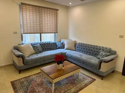 a living room with a couch and a table at Luxury Abdoun apartment in Amman