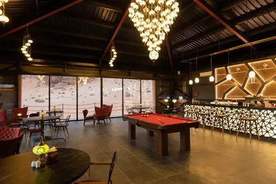 a ping pong table in a room with tables and chairs at Valley Resort in Wadi Rum