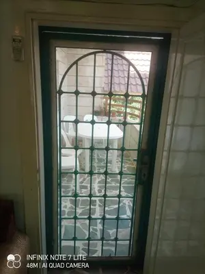 a glass door with a shelf of dishes at Decapolis with garden in Irbid