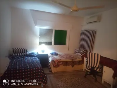 a bedroom with two beds and a window at Decapolis with garden in Irbid