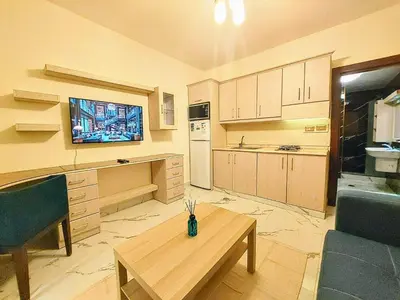 a living room with a table and a kitchen at Royal Luxury Amman Central Apartments in Amman
