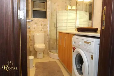 a bathroom with a toilet and a washing machine at Royal Luxury Amman Central Apartments in Amman