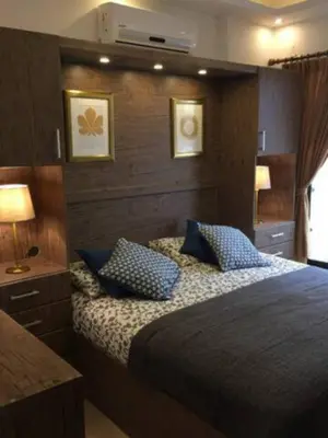 a bedroom with a bed with blue pillows at Royal Luxury Amman Central Apartments in Amman