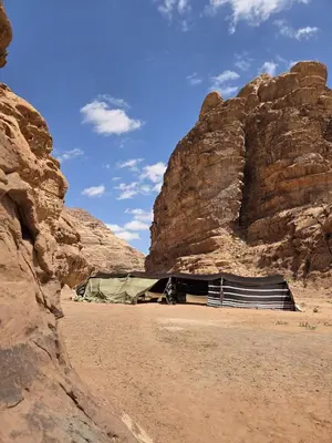 a tent in the desert next to some rocks at Luxury tent camp in Wadi Rum