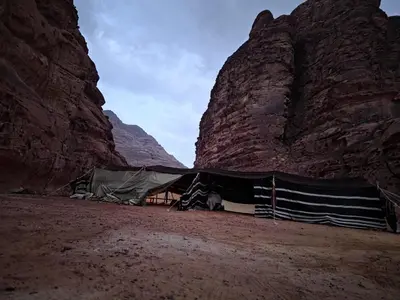 a tent in the middle of a desert with mountains at Luxury tent camp in Wadi Rum