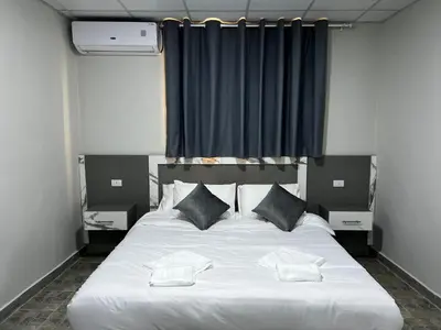 a bedroom with a large white bed with two pillows at Downtown Inn Madaba in Madaba