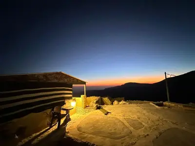 a table and a chair in the snow with the sunset at Dana Tower Hotel in Dana
