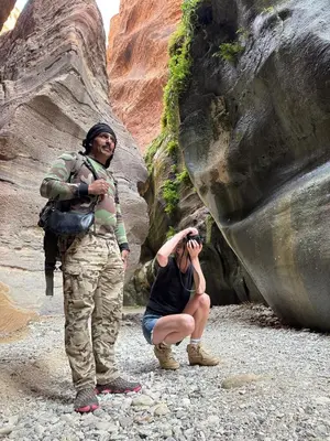 a woman taking a picture of two people in a canyon at Dana Tower Hotel in Dana