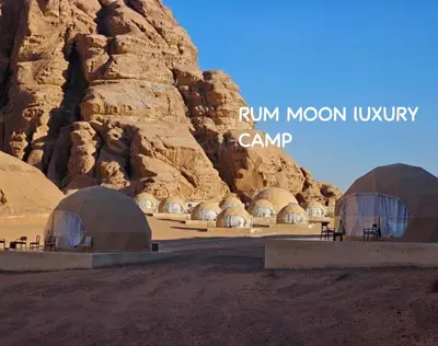 two domes in a desert with a rocky mountain at RUM MOON lUXURY CAMP in Wadi Rum