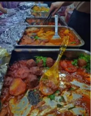 a buffet with many trays of food with a spoon at RUM MOON lUXURY CAMP in Wadi Rum