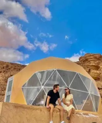 a man and a woman sitting in a tent at RUM MOON lUXURY CAMP in Wadi Rum