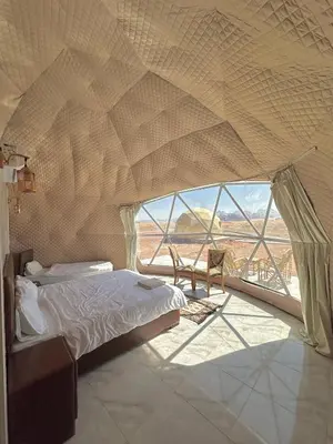 a bedroom with a bed and a large window at RUM MOON lUXURY CAMP in Wadi Rum