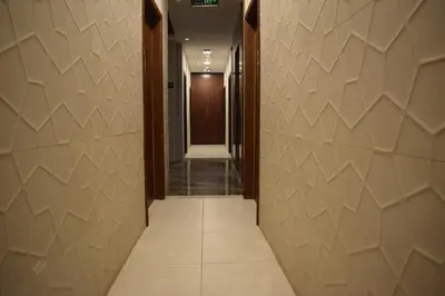 a corridor of a hallway with tile walls at Nour Hotel in Amman