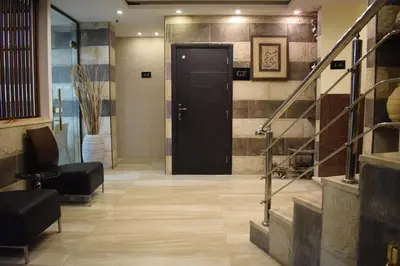 a lobby with a black door and a staircase at Nour Hotel in Amman