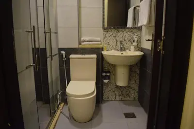 a bathroom with a toilet and a sink at Nour Hotel in Amman