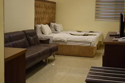 a hotel room with a bed and a couch at Nour Hotel in Amman