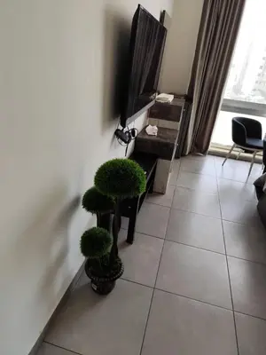 a living room with two potted plants on a tiled floor at Gentle Breeze Studio 1 in Amman