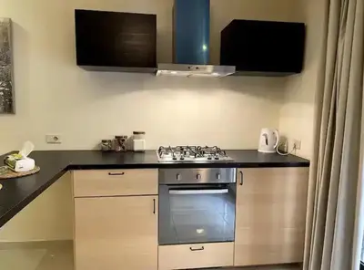 a kitchen with a stove and a counter top at Luxurious cozy apartment in Amman