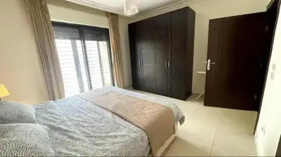 a bedroom with a bed and a large window at Luxurious cozy apartment in Amman