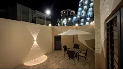 a patio with a table and chairs and an umbrella at Luxurious cozy apartment in Amman