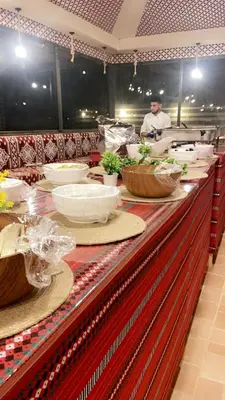 a buffet line with bowls of food in a restaurant at Dessert flowers wadi rum in Disah