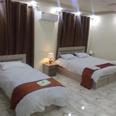 a bedroom with two beds and a lamp and curtains at Dream Hotel jerash in Jerash