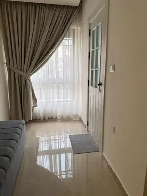 a living room with a couch and a large window at Luxury Family Apartment With Balcony in Amman