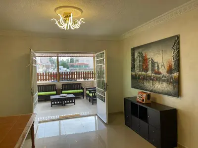 a living room with a chandelier and a living room with a table at Luxury Family Apartment With Balcony in Amman