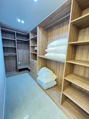 a walk in closet with wooden shelves and pillows at Luxury Family Apartment With Balcony in Amman