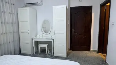 a white bathroom with a sink and a mirror at Luxury Family Apartment With Balcony in Amman