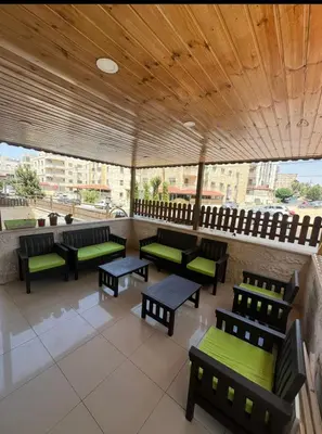 an outdoor seating area with benches and tables at Luxury Family Apartment With Balcony in Amman