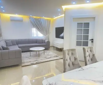 a living room with a couch and a table at Luxury Family Apartment With Balcony in Amman