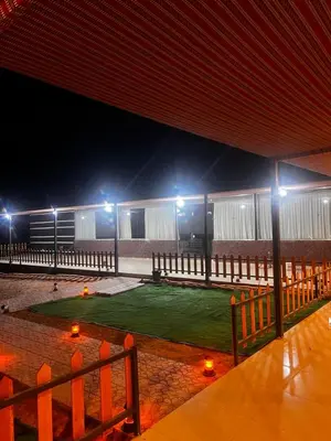 a building with a field of grass at night at WADI RuM GRAND in Wadi Rum