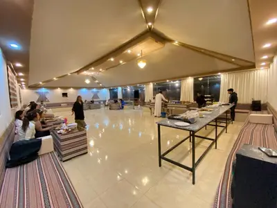 a lobby with people sitting at tables in a restaurant at WADI RuM GRAND in Wadi Rum