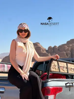 a woman sitting on the back of a truck at Nasa desert luxury camp in Wadi Rum