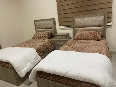 a bedroom with two beds and a headboard at Apartment for rent 50M fully furnished - in Amman