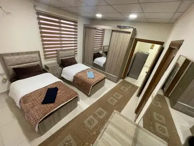 a large bedroom with two beds and a mirror at Apartment for rent 50M fully furnished - in Amman