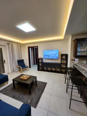 a large living room with a flat screen tv at Dair Ghbar - Amman Apartment in Amman