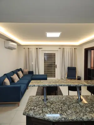a living room with a couch and a blue sofa at Dair Ghbar - Amman Apartment in Amman