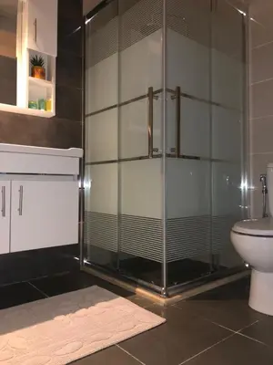 a bathroom with a glass shower with a toilet at Classy Guesthouse in Madaba