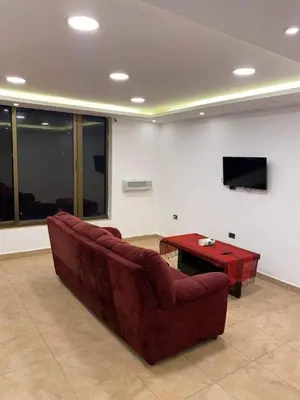 a living room with a red couch and a table at The view in Amman