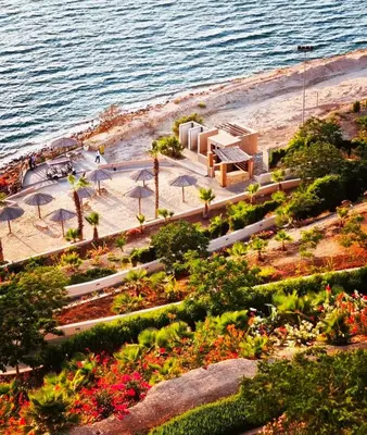 a park near the beach with umbrellas and the water at EP1 TWO BEDROOM APARTMENT AT Samarah Resort in Sowayma